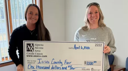 Community Foundation of Northeast Michigan Youth Advisory Council Members pose with a $505.00 check and posters advertising YAC Day